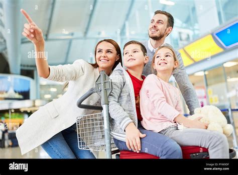 Familia Feliz Y Dos Hijos En La Terminal Del Aeropuerto En La Carretera