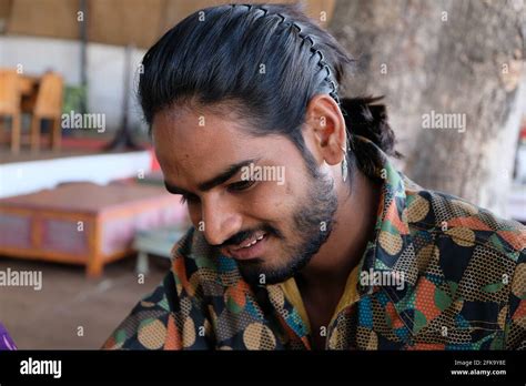 Portrait of a young handsome bearded Indian male with long hair wearing ...