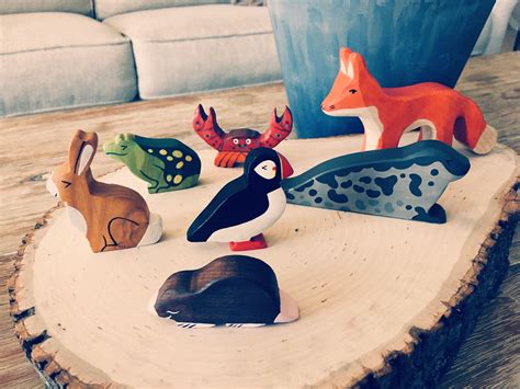 Small Wooden Animals Sitting On Top Of A Tree Stump