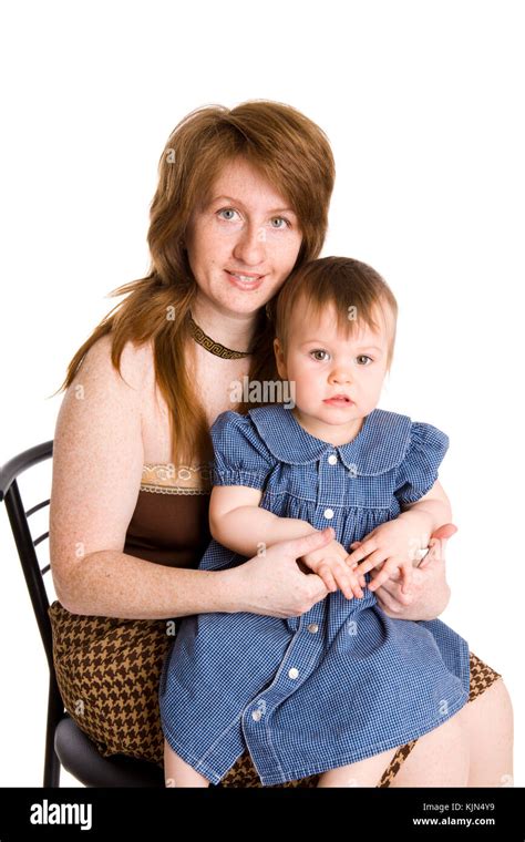 Redhead Mother And Daughter Sitting On Chair Isolated On White Stock