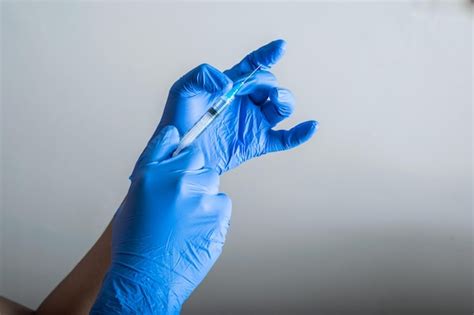 Premium Photo The Doctor S Hands With Blue Rubber Gloves Holding And