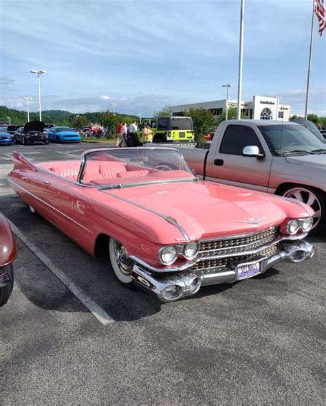 An Old Pink Car Parked In A Parking Lot