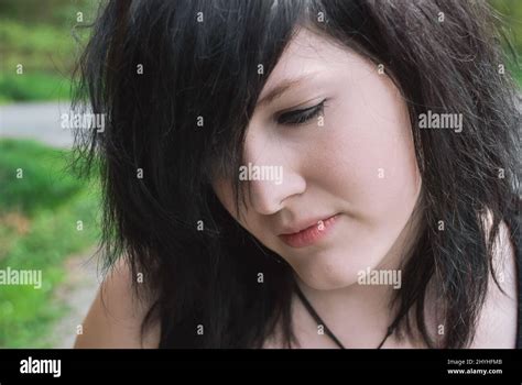 Gothic emo girl looking down with thoughtful facial expression, black ...