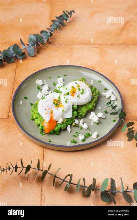 Green Peas With Poached Eggs On Sand Color Background Stock Photo Alamy