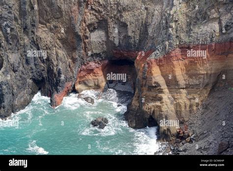 volcanic rock in the ocean with multi-colored layers Stock Photo - Alamy