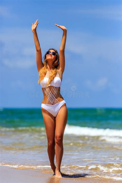 Modele En El Bikini Blanco Que Goza En La Playa Imagen De Archivo