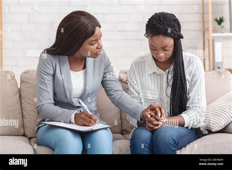 Psychologist Comforting Depressed Female Patient During Therapy Session