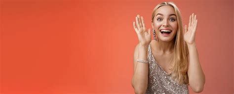 Impressionnée charmante divertie blonde Européenne femme dans une robe argentée et glamour