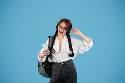 Chica adolescente caucásica feliz con coletas en gafas con auriculares