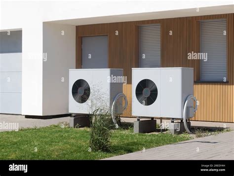 Two Eco Friendly Air Source Heat Pumps Situated In Front Of A Modern