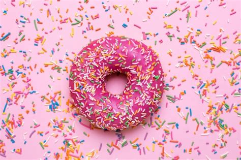 Premium Photo Sweet Pink Donut With Multicolored Sprinkles On A Pink