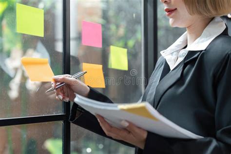 Happy Businesswoman Thinking Creative Ideas With Sticky Notes On Glass