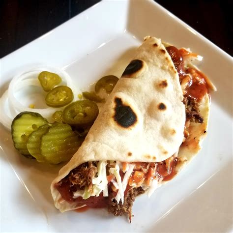 12 Hr Pulled Pork Wrapped In A Hand Rolled Tortilla Topped With Homemade Slaw And Tangy Sauce