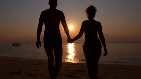 Romantic Couple Holding Hands At Sunset On Beach Stock Footage