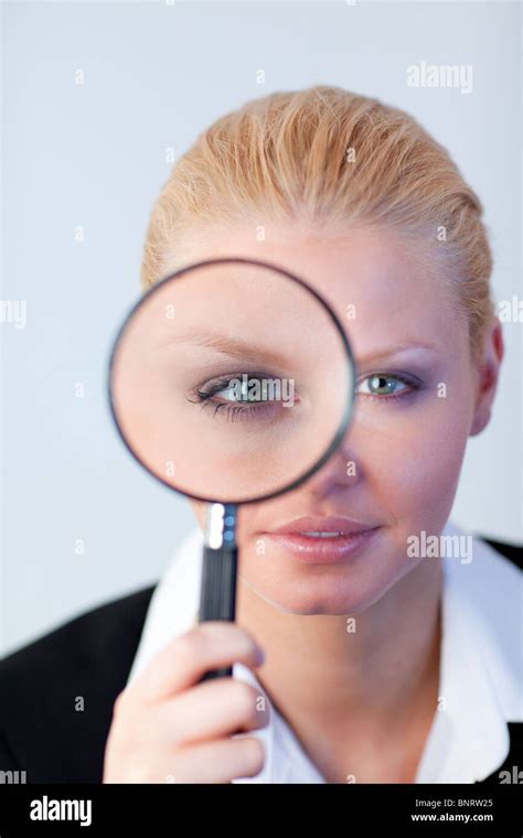 Serious Business Woman Looking Through A Magnifying Glass Stock Photo