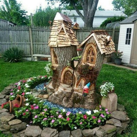 A Tree Stump Turned Into A Gnomes House With A Pond And Flowers