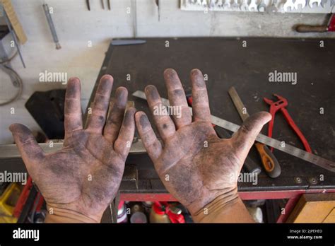 Image Of The Dirty Hands Of A Blacksmith Working In His Workshop With