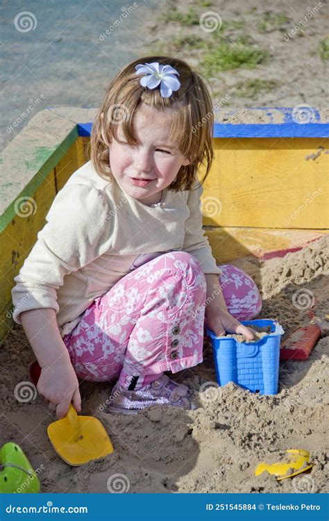 A Cute Little Girl Playing With Sand In Sandbox Stock Photo Image Of