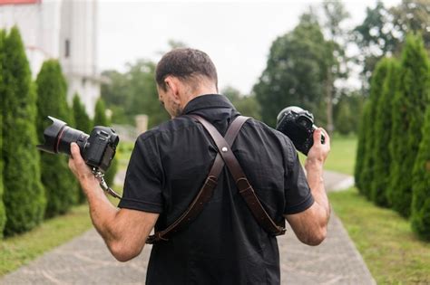 Premium Photo Professional Wedding Photographer In Black Shirt And With Shoulder Straps