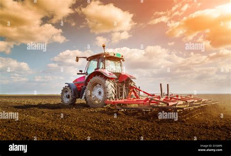 Farmer In Tractor Preparing Land With Seedbed Cultivator Stock Photo