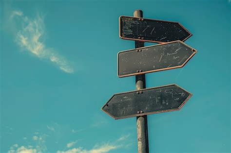 Blank Directional Road Signs Against Blue Sky Background Premium AI