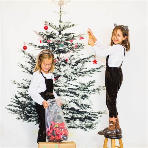 Free Photo | Two girls decorating christmas tree