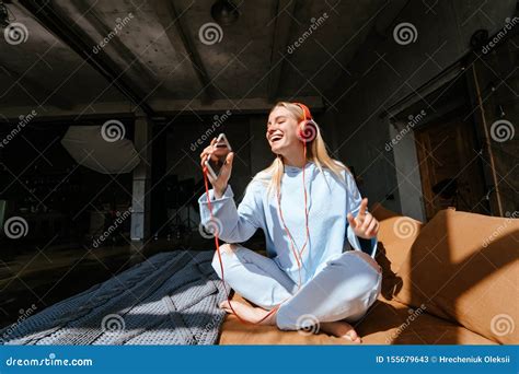 Natural Smiling Blonde Listening To Music In Bedroom Stock Image