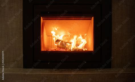 Fire flames and burning wood logs, fireplace on a wall, warm home in ...