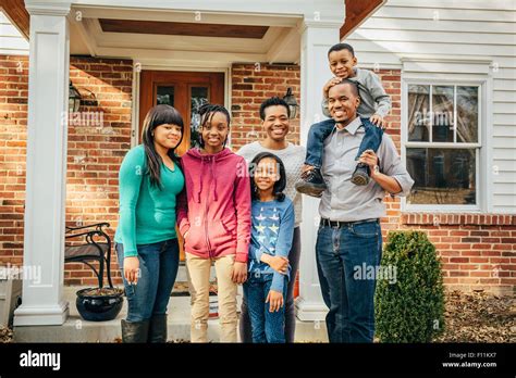 Black family smiling outside house Stock Photo - Alamy