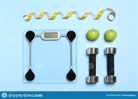 Flat Lay Composition With Floor Scales And Dumbbells On Light Blue