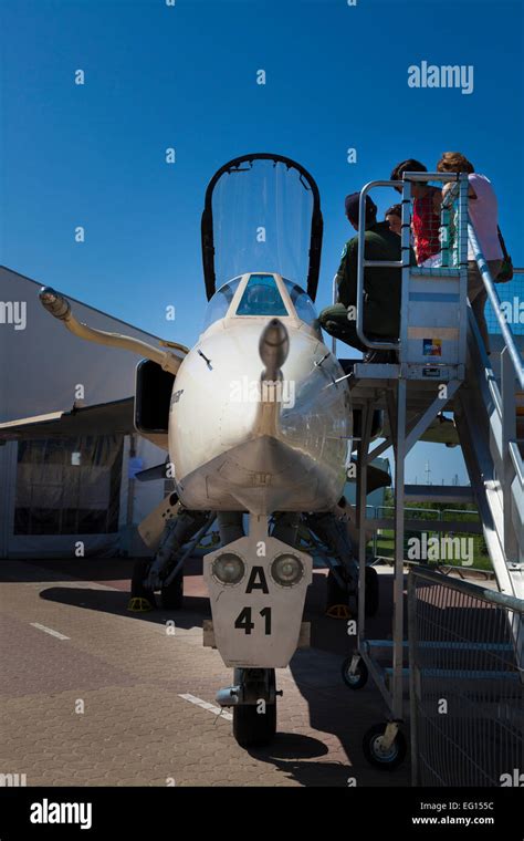 Visitors looking at the cockpit of Jaguar fighter plane on display at ...