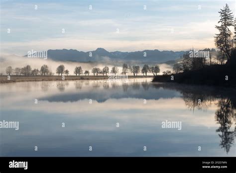 Sikes Lake reflects like a mirror on a calm morning under pastel blue skies in the Snoqualmie ...