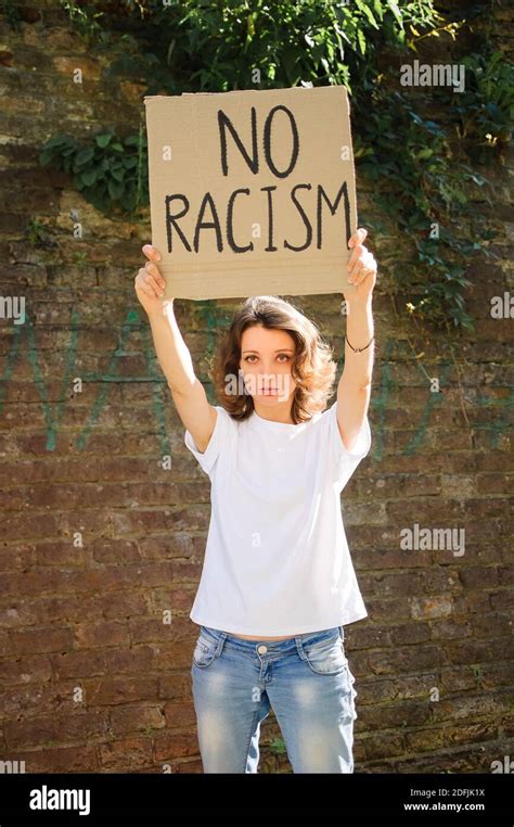 Upset Young Protesting Woman In White Shirt Holds Protest Sign