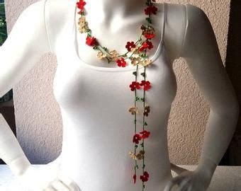 A Mannequin Wearing A White Bodysuit With Red Flowers On It S Neck