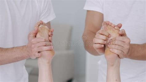 Two Male Masseurs Working With Woman Japanese Feet Massage With Bamboo