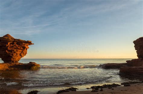 Rocas De La Piedra Arenisca Roja En La Alta Marea Foto De Archivo