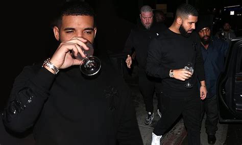 Drake Appears In High Spirits As He Sips His Drink While Leaving A Bar