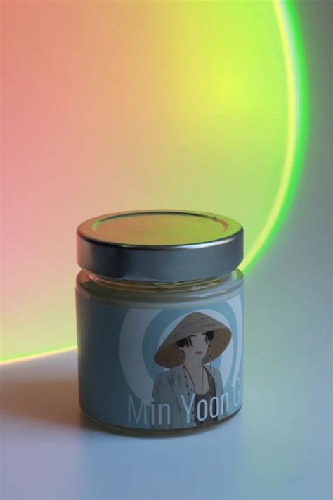 a small jar with an image of a woman in a hat on the front and side