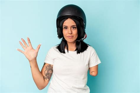 Joven mujer caucásica con un brazo que llevaba un casco de moto aislado