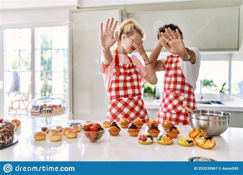 Couple Of Wife And Husband Cooking Pastries At The Kitchen Covering Eyes With Hands And Doing