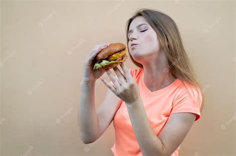 Premium Photo Young Beautiful Girl Eating A Hamburger