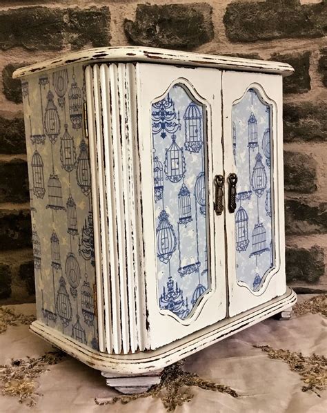 An Old White Cabinet With Blue And White Designs On The Doors Is