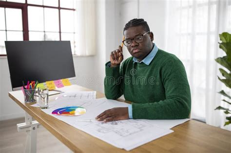 Thoughtful Black Engineer Man Working On Technical Drawing At Workplace