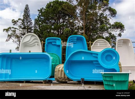 Various fiberglass pools in different shapes and color Stock Photo - Alamy