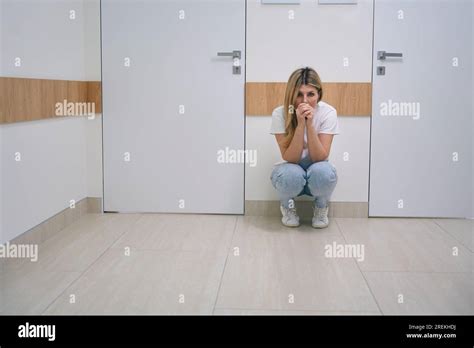 Female Blonde Woman In Jeans Is Squatting In Hospital Corridor Stock Photo Alamy