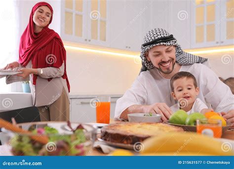 Familia Musulmana Feliz Comiendo Juntos En La Cocina Imagen De Archivo