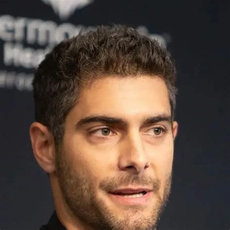 a close up of a person wearing a suit and tie with a black shirt on