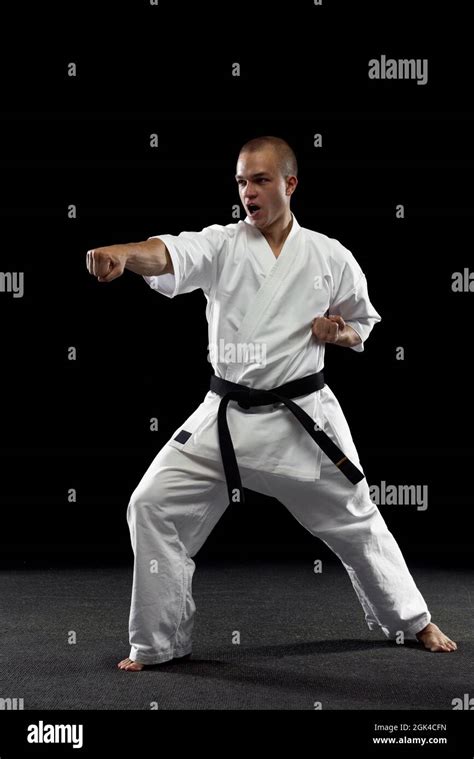 Full-length portrait of young sportsman training karate isolated over ...