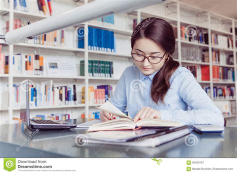 Estudante De Jovem Mulher Que Aprende Na Biblioteca Imagem De Stock