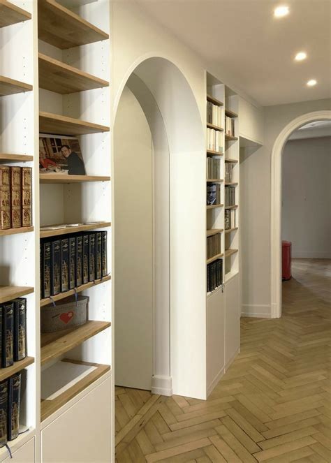 An Empty Room With Bookshelves In The Middle And Wooden Floors On Both